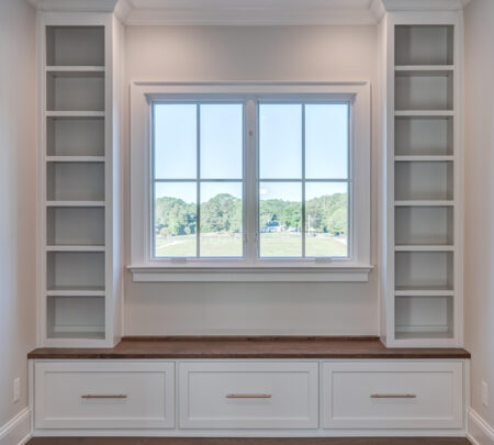 window surrounded by built-in shelving and under-seating storage