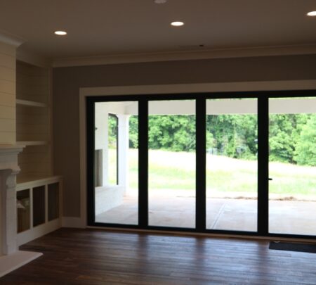 fireplace, built-in shelving and storage, full-wall windows and doors